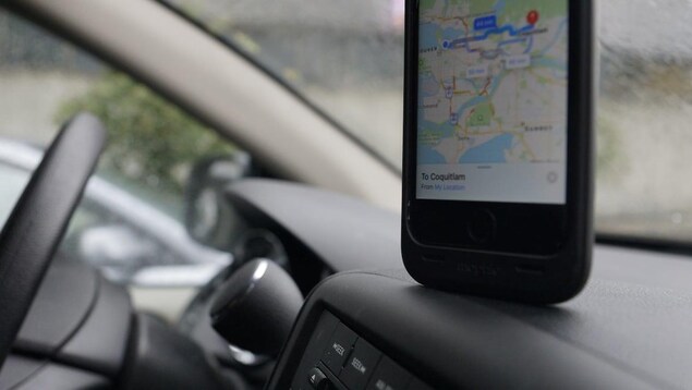Un appareil cellulaire sur le tableau de bord d'une voiture.