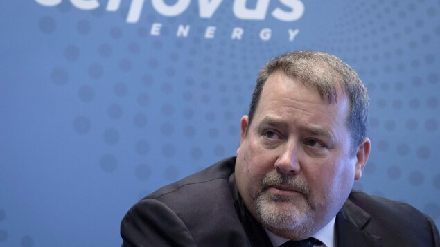 Alex Pourbaix regarde vers la gauche devant un mur bleu avec le logo de Cenovus. Alex Pourbaix regarde vers la gauche devant un mur bleu avec le logo de Cenovus.