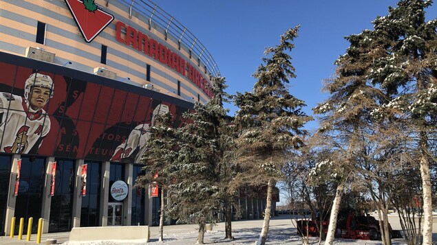 Le Centre Canadian Tire avec, en avant-plan, quelques sapins enneigés.
