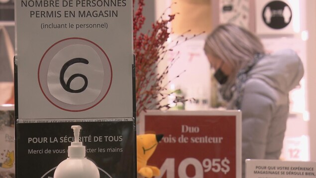 Una pancarte indique le nombre de personnes admises dans un magasin.