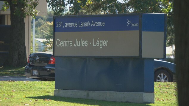 Un panneau bleu et gris indique l'adresse et le nom du Centre Jules-Léger devant l'établissement
