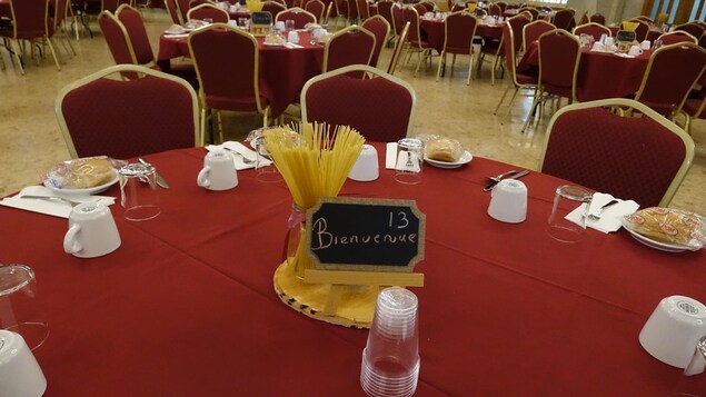 Une table ronde avec des couverts et au centre un petit tableau noir où on peut lire le mot bienvenue Une table ronde avec des couverts et au centre un petit tableau noir où on peut lire le mot bienvenue