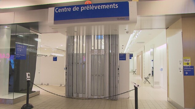 Une porte dans un centre commercial donne sur des locaux blancs.