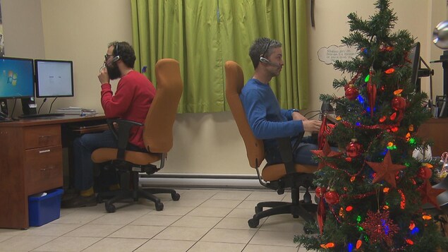 Deux intervenants répondent aux appels avec des casques d'écoute.