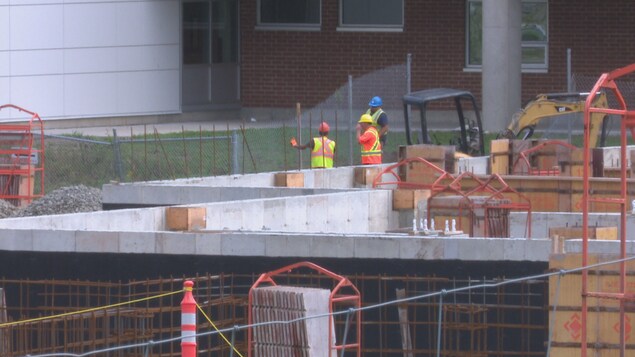 Des travailleurs œuvrent à la construction du centre. Des travailleurs œuvrent à la construction du centre.