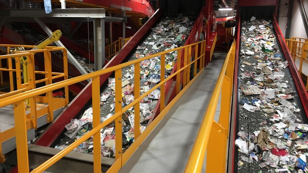 Des objets à recycler sont déployés sur un convoyeur.