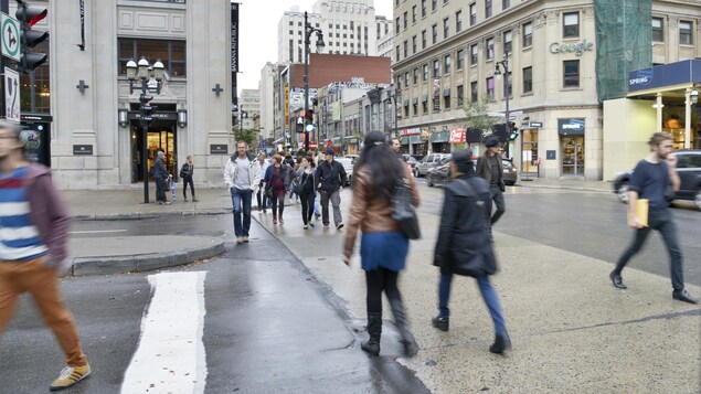 Des piétons marchant sur la rue Sainte-Catherine à Montréal.