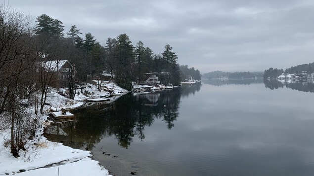 Des chalets et des quais enneigés au bord d'un lac.