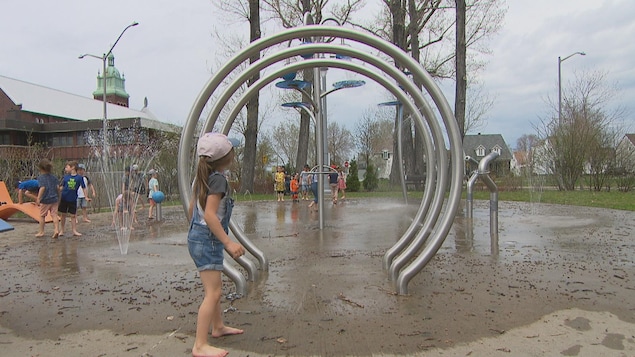 Une jeune fille s'amuse dans les jeux d'eau.