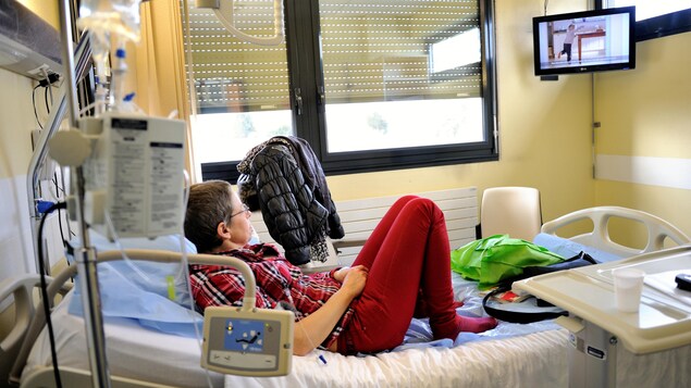 Une patiente regarde la télévision alors qu'elle se repose dans sa chambre d'hôpital à Lille, en France, le 6 février 2013.