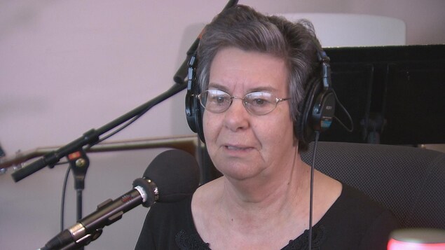Une femme coiffée d'écouteurs devant un micro Une femme coiffée d'écouteurs devant un micro