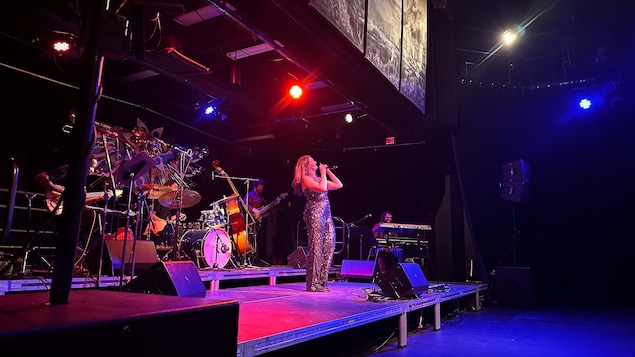 Une femme qui chante sur scène.