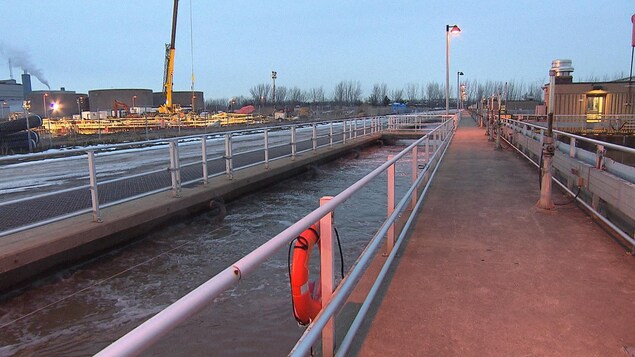 Un bassin rempli d'eau, alors qu'on voit une grue sur un chantier à l'arrière. Un bassin rempli d'eau, alors qu'on voit une grue sur un chantier à l'arrière.