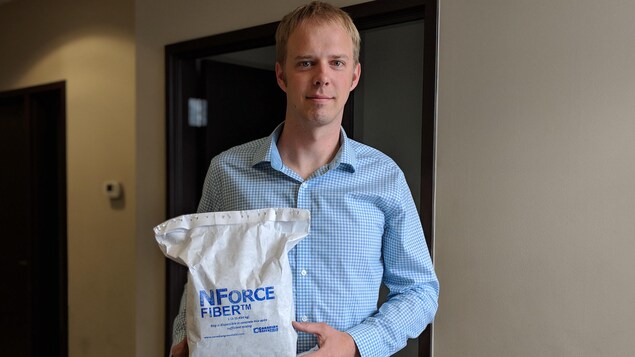 Portrait d'un homme blond qui tient dans ses mains un sac de NForce-Fiber qui a été envoyé en Chine. Portrait d'un homme blond qui tient dans ses mains un sac de NForce-Fiber qui a été envoyé en Chine.