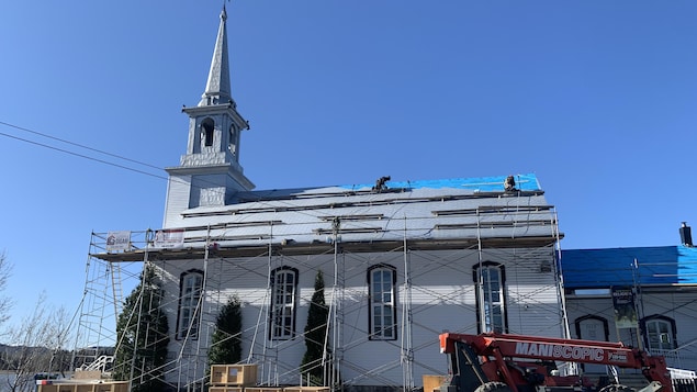 Des échafaudages sont installés à l'extérieur de la chapelle et des ouvrier travaillent sur la toiture.