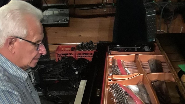 Charles Tanguay manipule les cordes d'un piano.