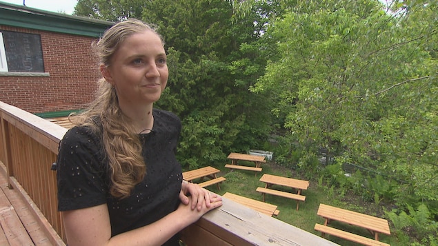 Elle se tient sur la terrasse du restaurant. 