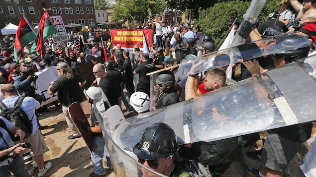 Des manifestants de l'extrême droite sont munis de boucliers et de casques pour avancer à travers la mêlée Des manifestants de l'extrême droite sont munis de boucliers et de casques pour avancer à travers la mêlée