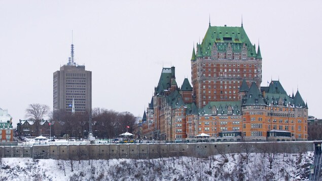 Le château Frontenac est bien visible au-dessus du cap blanc. On peut voir le traversier Québec-Lévis en avant-plan.