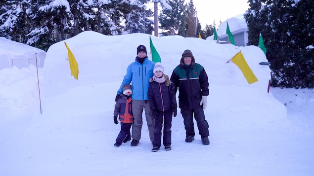 Les membres de la famille Bélec-Maltais pose devant son château de neige.