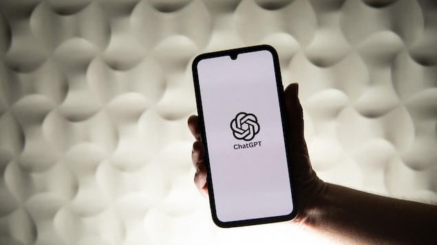 Une personne tient un téléphone affichant le logo de l'intelligence artificielle ChatGPT, d'OpenAI.