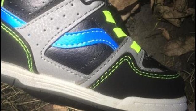 Une chaussure noire, grise et bleue avec des lacets jaunes Une chaussure noire, grise et bleue avec des lacets jaunes