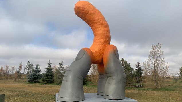 La statue Cheetle Hand : trois doigts recouverts de poudre des fameuses croustilles Cheetos tiennent une croustille.
