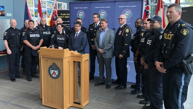 Une dizaine de policiers devant un podium Une dizaine de policiers devant un podium