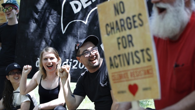 Chelsea Manning et Dylan Petrohilos sont souriants et ont le poing levé en guise de protestation. Chelsea Manning et Dylan Petrohilos sont souriants et ont le poing levé en guise de protestation.