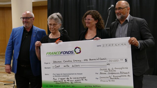 Daniel Boucher,  Joanne Lewandoski, Maxine Robert et Daniel Lussier tiennent un chèque le 27 septembre 2022 au sous-sol de la cathédrale de Saint-Boniface, à Winnipeg.