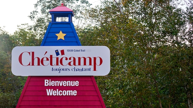 Un phare aux couleurs de l'Acadie avec l'écriteau Chéticamp.