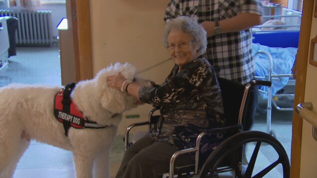 Une résidente avec un chien de thérapie.