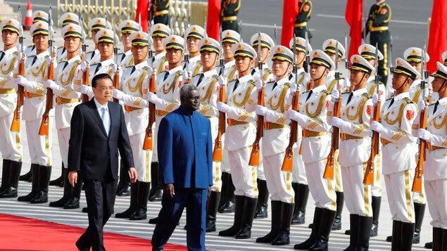 Solomon Islands Prime Minister Manasseh Sogavare is welcomed in China by then-premier Li Keqiang in 2019. Sogavare has since signed a security pact with China and delayed elections. (Thomas Peter/Reuters)