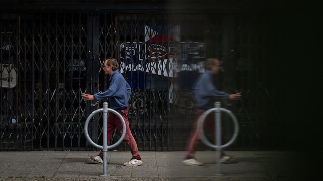 A man walking by a closed store.