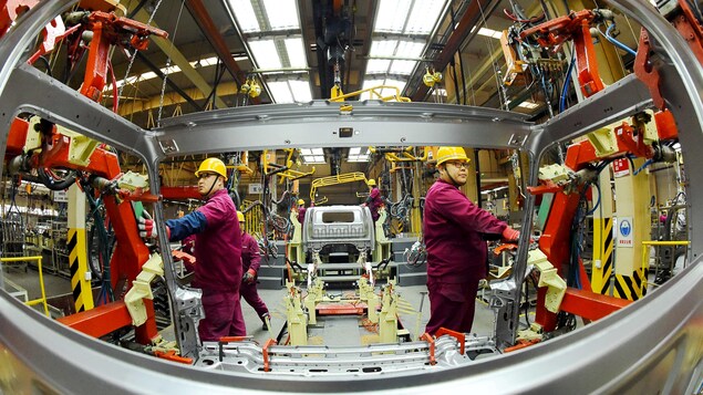 Des employés travaillent sur une chaîne de production fabriquant des camions légers dans une usine de JAC Motors à Weifang, province de Shandong, Chine, le 30 novembre 2018.