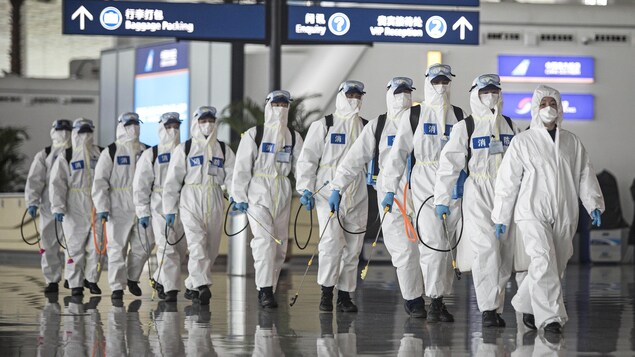 Une équipe de désinfection à l'oeuvre dans un aéroport de Chine.