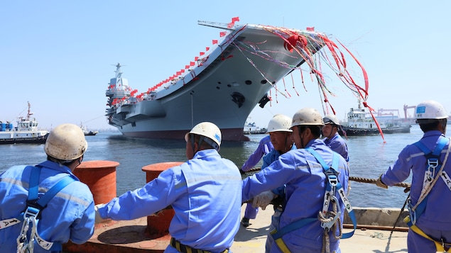 Des ouvriers chinois regardant le porte-avions Shandong. Des ouvriers chinois regardant le porte-avions Shandong.