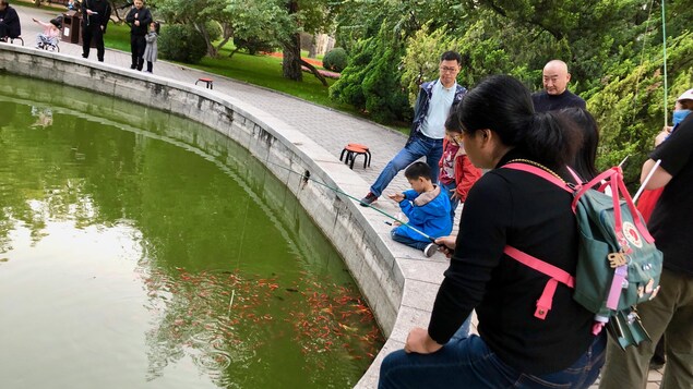 Des enfants et leurs parents tiennent des cannes à pêche.