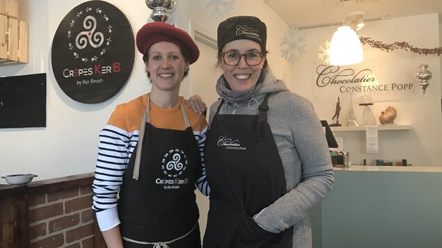 Deux femmes portant un tablier de cuisine et un chapeau