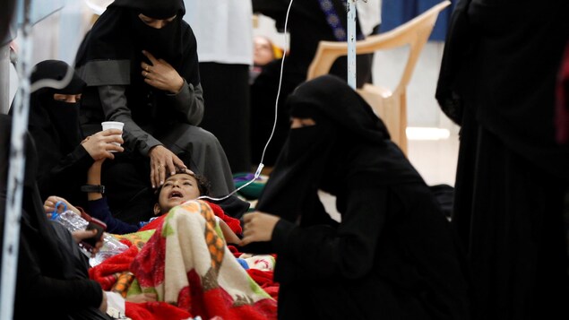 Un enfant intubé est entouré de femmes vêtues de niqabs. Un enfant intubé est entouré de femmes vêtues de niqabs.