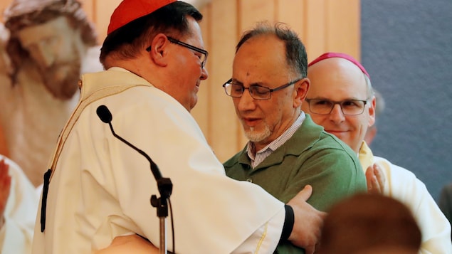 Le cardinal Cyprien Lacroix donne l'accolade au cofondateur du Centre culturel islamique de Québec Boufeldja Benabdallah lors d'une messe à Sainte-Foy. Le cardinal Cyprien Lacroix donne l'accolade au cofondateur du Centre culturel islamique de Québec Boufeldja Benabdallah lors d'une messe à Sainte-Foy.