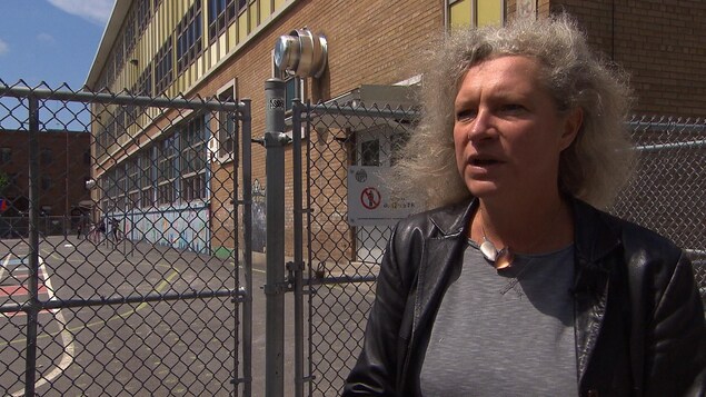 Une femme dans une cour d'école parle à la caméra. Une femme dans une cour d'école parle à la caméra.