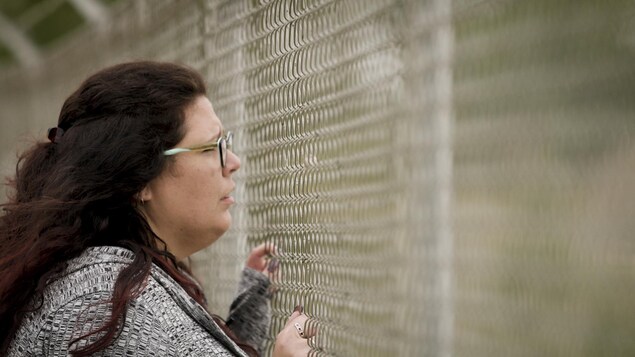 Christie-Anne Blondeau qui regarde à travers une clôturel'air triste. Christie-Anne Blondeau qui regarde à travers une clôturel'air triste.