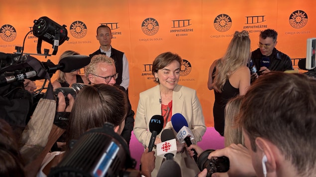Christine Fréchette sur le tapis rouge avec plusieurs journalistes.