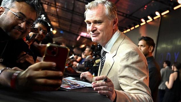 Christopher Nolan signe un autographe.