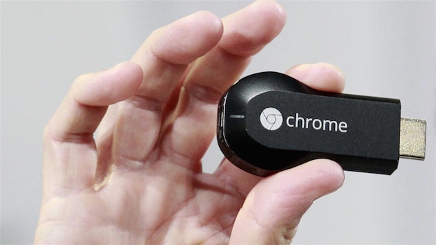 Un petit appareil ressemblant à une clé USB est tenu entre deux doigts d'une main. 