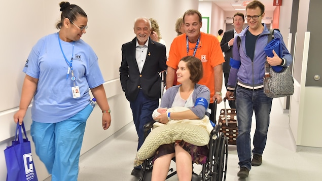 Des infirmiers et des bénévoles, dont l'humoriste Yvon Deschamps, participent au transfert de la première patiente de l'hôpital Saint-Luc vers le nouveau CHUM.