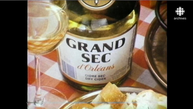 Bouteille de cidre, accompagnée d'une coupe remplie et de croûtons de pain