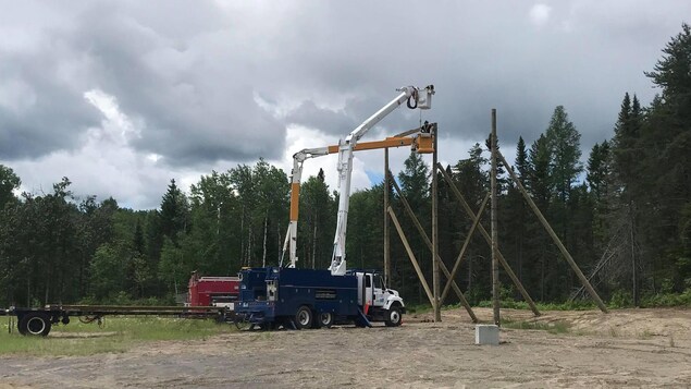 Des employés dans des grues installent des équipements.