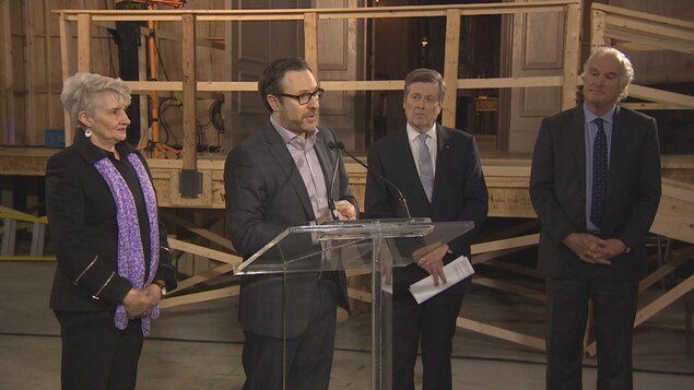 Jim Mirkopoulos, vp de Cinespace, annonce la transformation de deux terminaux maritimes en studios de cinéma sur le plateau de la série télévisée La servante écarlate. Jim Mirkopoulos, vp de Cinespace, annonce la transformation de deux terminaux maritimes en studios de cinéma sur le plateau de la série télévisée La servante écarlate.